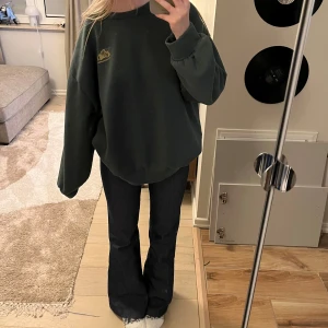Grön sweatshirt - Mysig mörkgrön sweatshirt med tryck på ryggen. Tröjan är storlek S, men har en oversized passform💚