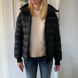 Svart Peak performance jacka  - Peak Performance, tomic insulated hood jacket W i storlek S  Ny pris 2799kr, säljs för 1799kr Köpt på Skistar september 2023, helt i ny skick 
