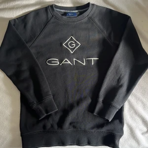 Gant hoodie - svart gant hoddie med vit text på framsidan. Den är bara använd bara 1 gång, ren och tvättad.
