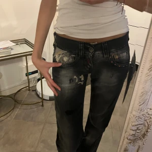 Replay jeans - Extremt låga jeans med snygga tryck. Jeansen passar mig som är 164 cm lång. Jeansen har en liten svart fläck på byxorna, men märks inte då den passar in med trycken. (Därav priset). Straight jeans