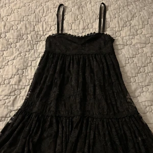 Kort svart flowy klänning - Svart, flowy och blommig klänning i storlek S som går till mitten på mina lår, (jag är 160cm). Den har knappt använts och är i mycket bra skick!