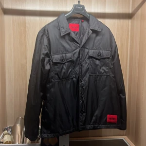 Hugo boss dun overshirt - Väldigt fin Dun overshirt från hugo boss. Sparsamt använd och inga fel på den alls. Nypris 2300. Vid frågor eller fler bilder så är det bara att höra av sig.