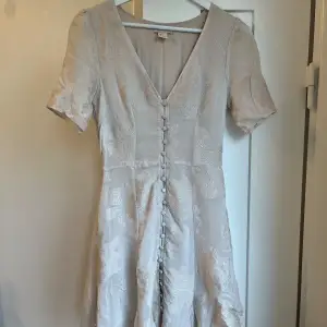 H&M conscious collection supersöt klänning med broderade blommor och knappar i fram, färg naturvit/beige