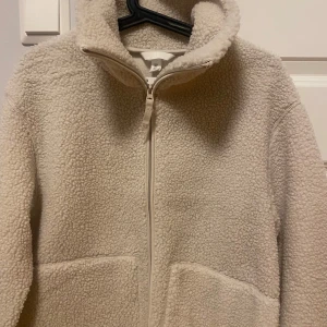 NY Pilejacka / Teddyjacka från HM - Ny med tags pilejacka i ljusbeige / naturvit i stl M.  Passformen är i en normal avslappnad form. Ta en storlek större än din vanliga storlek om du vill ha plats för en tjocktröja under annars kan det blir lite tajt.