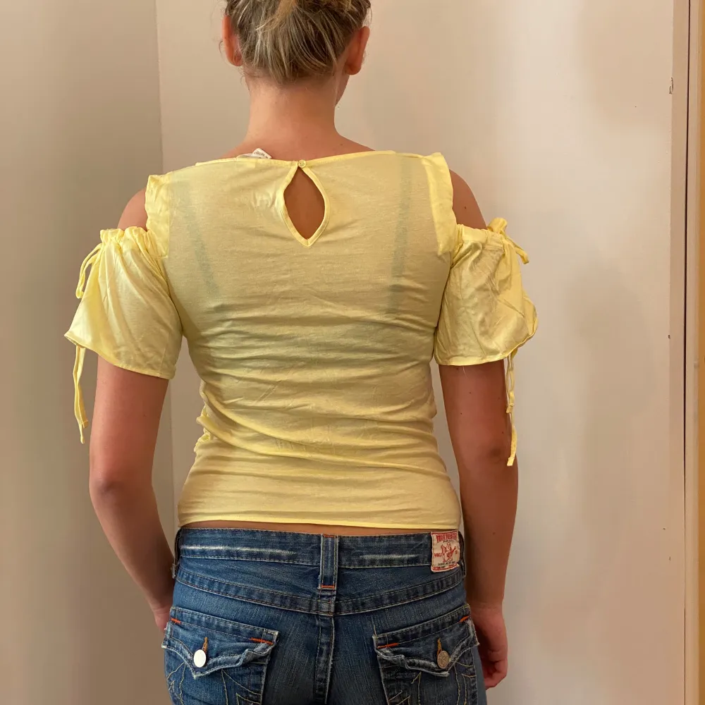 Säljer en söt gul topp från H&M Mama i storlek XS. Toppen har korta ärmar med volangdetaljer och en liten öppning i ryggen. Perfekt för vår och sommar! 💛. Yläosat.
