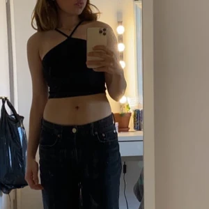 Svart oneshoulder topp - Snygg svart oneshoulder topp som är perfekt för en kväll ute. Den är croppad och har en stilren design som passar till många olika outfits.