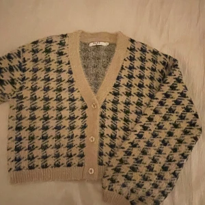 Svart beige v-ringad kofta - Supermysig kofta från NA-KD med supercoolt mönster! Inga defekter, säljer då de inte kommer till användning🩷🩷