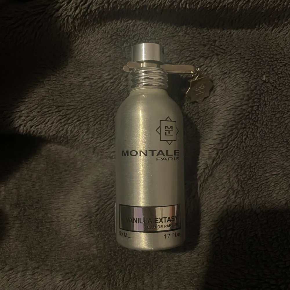 Säljer en flaska Vanilla Extasy Eau de Parfum från Montale. Flaskan är i en elegant silverfärg med en praktisk sprayfunktion och en liten dekorativ berlock. Perfekt för dig som älskar doften av vanilj och vill ha något lyxigt i din samling. Cirka halva parfymen finns kvar. 50 ml. Perfume.
