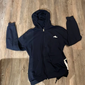 Mörkblå hoodie från Replay - Säljer en snygg mörkblå hoodie från Replay med dragkedja och stor logga på sidan. Perfekt för en avslappnad stil. Den har långa ärmar och en praktisk huva. Skriv gärna om ni är intresserade eller har frågor om mer bilder 
