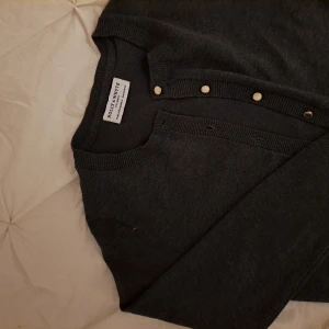 Mörkgrå kofta - Säljer en stilren mörkgrå kofta från Holly & Whyte. Koftan har knappar framtill och är mjuk och bekväm, idealisk för kyligare dagar. Superfint skick och tröjan saknar defekter! Pris är diskuterbart och tveka inte att höra av dig vid frågor och funderingar ❤️