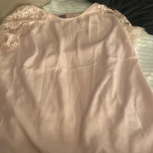 Rosa blus med spetsdetaljer från Gina Tricot - Säljer en söt rosa blus från Gina Tricot med spetsdetaljer på axlarna. Perfekt för en romantisk look. Blusen har en mjuk och bekväm passform. 