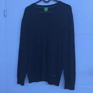 Svart tröja från Hugo Boss - Snygg svart tröja från Hugo Boss med diskret logga på bröstet. Tröjan har långa ärmar och en klassisk passform. Perfekt för en stilren look.