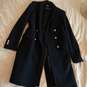 Marinblå kappa från Zara - Elegant marinblå kappa från Zara med guldknappar. Den har en klassisk design med lång ärm och är perfekt för höst och vinter. Gjord av högkvalitativt material från Manteco. nästan aldrig använd! 