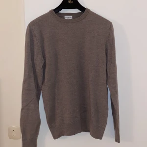 John Henric Tröja i Merinoull - Vi säljer nu en stilren beige stickad tröja i merinoull från John Henricmed rund hals och långa ärmar. Perfekt för en avslappnad look. Modellen är 181 och väger 68 kg✅