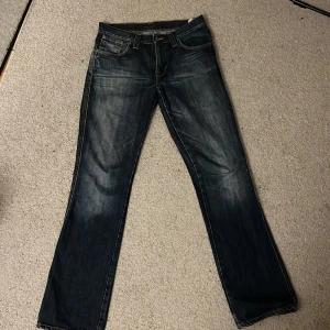 Mörkblå jeans från Nudie Jeans - Snygga mörkblå jeans från Nudie Jeans med klassisk femficksdesign och kontrastsömmar, lågmidjade och bra material. Passar för folk som har 36-38 i byxor.