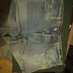 Ljusblå lowwaist jeansshorts - Snygga ljusblå jeansshorts från Episode med knappar framtill. Perfekta för en avslappnad stil. De har en klassisk design med fem fickor. L