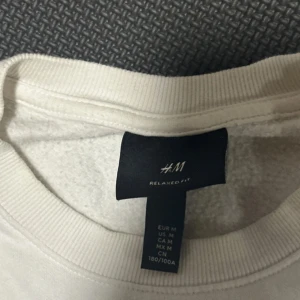 Vit tröja från H&M - Säljer en vit tröja från H&M i relaxed fit. Tröjan har långa ärmar och en rund halsringning. Perfekt för en avslappnad stil. Passar bra till jeans eller mjukisbyxor.