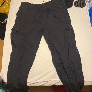 Svarta cargobyxor från Firefly - Säljer ett par svarta cargobyxor från Firefly. Byxorna har flera praktiska fickor på sidorna och en bekväm passform. Perfekta för en avslappnad stil.