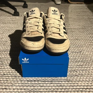 Adidas forum low - Säljer ett par klassiska Adidas sneakers i beige och svart. Skorna är rätt använda men fortfarande i bra skick 