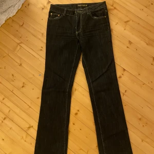 Mörkblå jeans med guld detalj - Snygga mörkblå jeans med unika broderade detaljer på bakfickorna, guldigt glitter i byxorna. De är midwaist, bootcut och passar mig som bär S/178cm lång