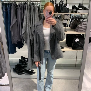 Grå kappa - Snygg grå kappa med breda slag och en klassisk design. Perfekt för kyligare dagar och ger en stilren look. Passar bra till både jeans och mer uppklädda outfits. Endast använd ett fåtal gånger!