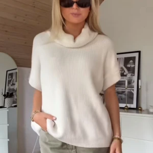 Vit stickad polotröja - Säljer en stilren vit stickad polotröja med korta ärmar. Perfekt för en avslappnad och trendig look. Tröjan har en mjuk och bekväm passform med en elegant polokrage.