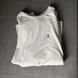 Grå långärmad tröja från Ralph Lauren - Säljer en stilren grå långärmad tröja från Ralph Lauren med det klassiska broderade logotypen på bröstet. 