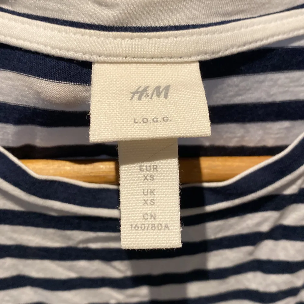 Säljer en randig klänning från H&M i storlek XS. Klänningen har ett klassiskt blått och vitt randigt mönster och korta ärmar. Perfekt för en avslappnad stil. Tillverkad i ett mjukt och bekvämt material.. Mekot.
