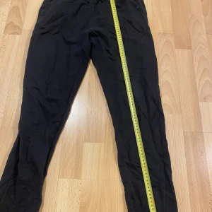 Svarta byxor från Lager 157 - Svarta byxor från Lager 157 i 100% bomull. De har en enkel design med elastisk midja för extra komfort. Perfekta för en avslappnad stil.