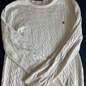 Vit kabelstickad tröja från Morris - Säljer en stilren vit stickad tröja från Morris med kabelstickat mönster. Den är storlek L men passar mig som är M. Tröjan har användts i ungefär 2-3 månader efter att vi köpt den som ny så den är i perfekt skick! Pris går att diskutera, hör av er vid frågor eller funderingar💯