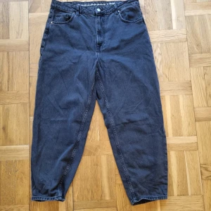 Svarta jeans från Never Denim - Säljer ett par svarta jeans från Never Denim i storlek 32. De är tillverkade av 100% bomull och har en klassisk femficksdesign. Byxorna har en knapp och dragkedja framtill. Perfekta för en avslappnad stil!