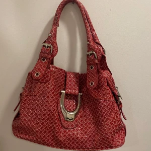 Röd väska - Röd väska med silverdetaljer. Rymlig och funkar runt axeln💞