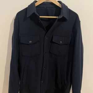J lindberg - J lindberg overshirt i färgen mörkblå.  Inga skador eller som påverkar jackan. Nypris runt 2300kr. Skriv för frågor och funderingar. 