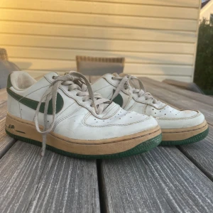 Air force 1 - Air force 1 med gröna detaljer. Har använt i ungefär 1 år men de passar inte i storlek längre. Det finns synliga skador som skråmor på sidan.