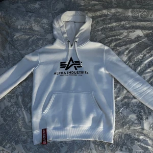 Alpha Industries Hoodie Vit - Säljer hoodie jag växt ut ur. Mycket bra skick, använd ett fåtal gånger. Jätteskön och varm. 8/10