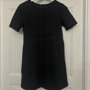 Svart kortklänning från Zara - Säljer en mörk grå klänning från Zara. Storlek S. Använd en gång och har inga defekter. 