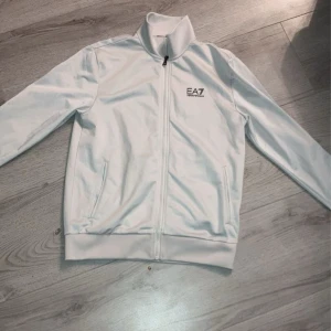 Ea7/Armani dress vit.  - Hej! Säljer min vita Armani dress pågrund av att den inte används längre, skicket är riktigt bra. Storlek är S på både tröjan och byxan. 