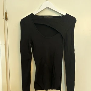 Svart långärmad - Väldigt fin, svart långärmad med detalj över bröst från BikBok, samt fina ”skurningar” nedtill på sidorna. Endast använd en gång. Storlek S.  (Ordinariepris 399kr)