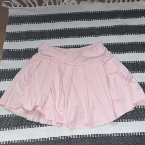 Rosa kjol med shorts - En ljusrosa kjol med fastsydda shorts under. Den är lite mer rosa i verkligheten än på bilderna🩷 Det är en ficka på shortsen. Endast använd vid 1 tillfälle, nytvättad. Stl XS/S, ganska mycket stretch.  Skriv gärna vid frågor eller prisförslag💕
