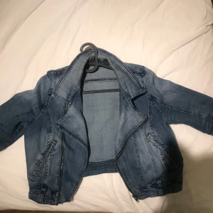 Blå jeansjacka med dragkedja - Snygg blå jeansjacka med dragkedja och cool design. Jackan har en croppad passform, perfekt om du letar efter nåt som är i kategorin ’grunge’ eller ’y2k’ !! 