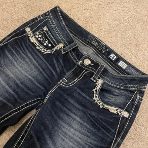 Mörkblå jeans från Miss Me - Miss me jeans i mörkblå som är uppsydda, passar mig som är 162. I storlek 26, säljer pga att de ej kommer till användning.