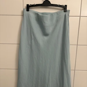 Ljusblå kjol från Bik Bok - Snygg ljusblå midikjol från Bik Bok i en enkel och stilren design. Perfekt för en avslappnad och chic look. Kjolen har en mjuk och skön känsla.