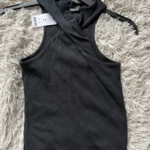 Svart ribbad Najila tank - Snygg svart ribbad tanktopp från Najila med en unik design. Perfekt för en stilren look.