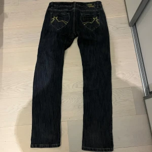 Lågmidjade jeans - Mörkblå lågmidjade jeans med super snygga detaljer. Storlek L men jag skulle säga att de är M.