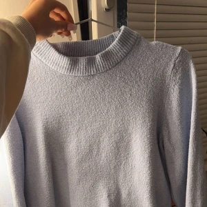 Ljusblå stickad tröja - Mysig ljusblå stickad tröja med ribbade detaljer vid hals, ärmslut och nederkant. 