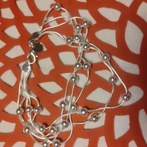 925 silver armband Nytt  - Elegant silver 925 armband med flera rader av små kulor. Mörkt 925 på den lilla brickan vid låset. Det är helt nytt .                        Perfekt för att ge en stilren touch till din outfit. Armbandet har en enkel låsning och en modern design.