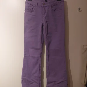 Lila Jeans - Snygga lågmidjade jeans i storlek 34 eller w24/w25/w26. Längden passar L30-L32. Byxorna har modellen bootcut. Passar till vardags och fest! Perfekta för att addera lite färg till garderoben.