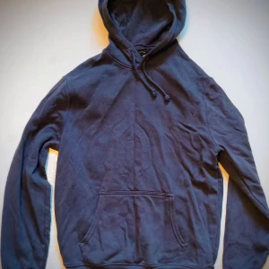 Mörkblå hoodie - Säljer en stilren mörkblå hoodie med justerbar huva och praktisk magficka. Perfekt för en avslappnad look.