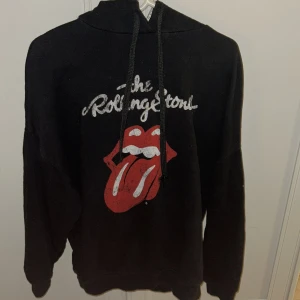 Svart hoodie med Rolling Stones-tryck - Säljer denna as feta hoodie men unikt tryck som är i str XS. Tveka inte på att kontakta mig vid minsta fundering eller eventuella frågor🙌