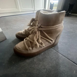 Inuikii beiga skor - Säljer mina beiga Inuikii-skor i toppskick, sparsamt använda och riktigt varma, perfekta för vintern! Nypris var 3000 kr. Storlek: 38. Kan fraktas eller hämtas i Täby. Hör av dig om du är intresserad!🤍